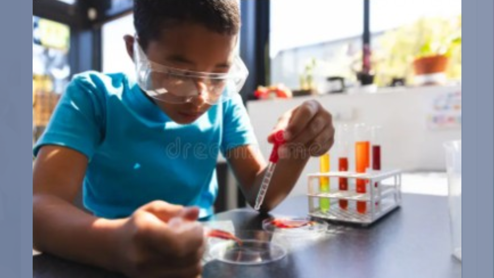 Black middle school male student doing experiment with test tubes