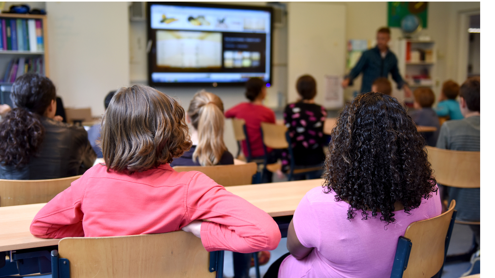 Middle school students watching teacher at front of room