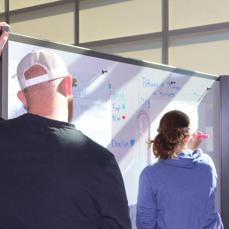 Participants writing on whiteboard