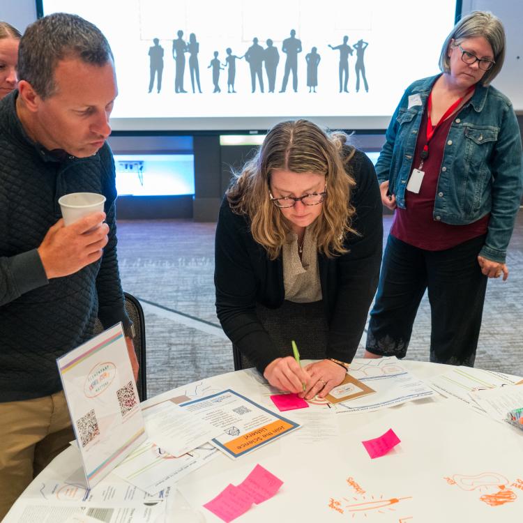Attendee writing post-it note