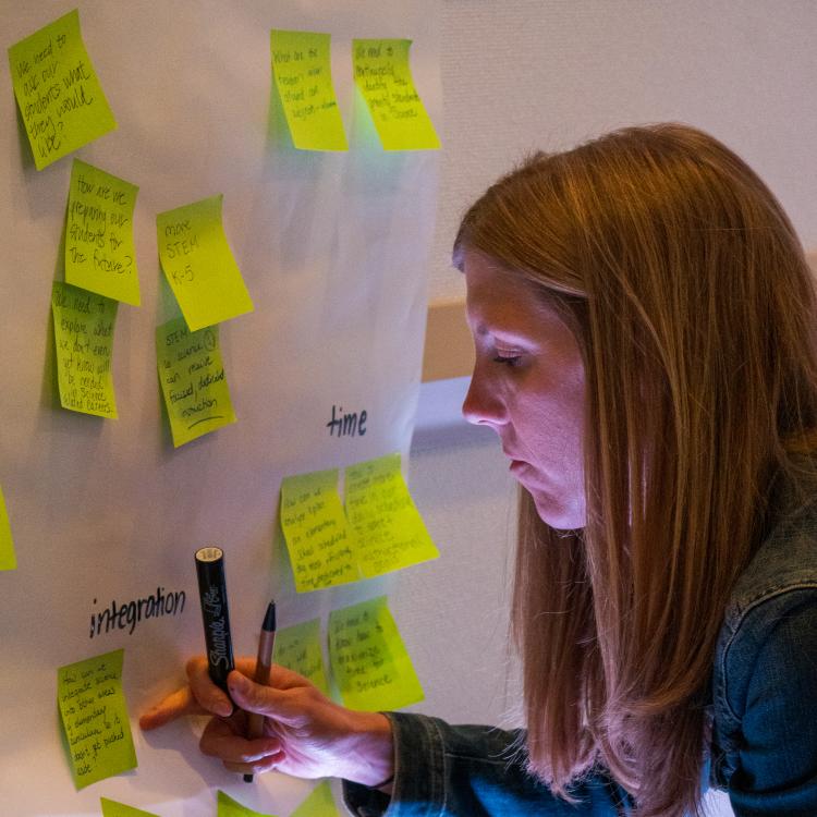 Attendee writing post-it note