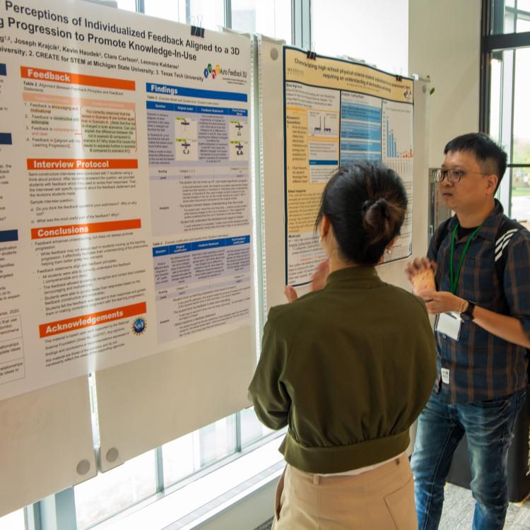 Mao-Jen and female looking at poster