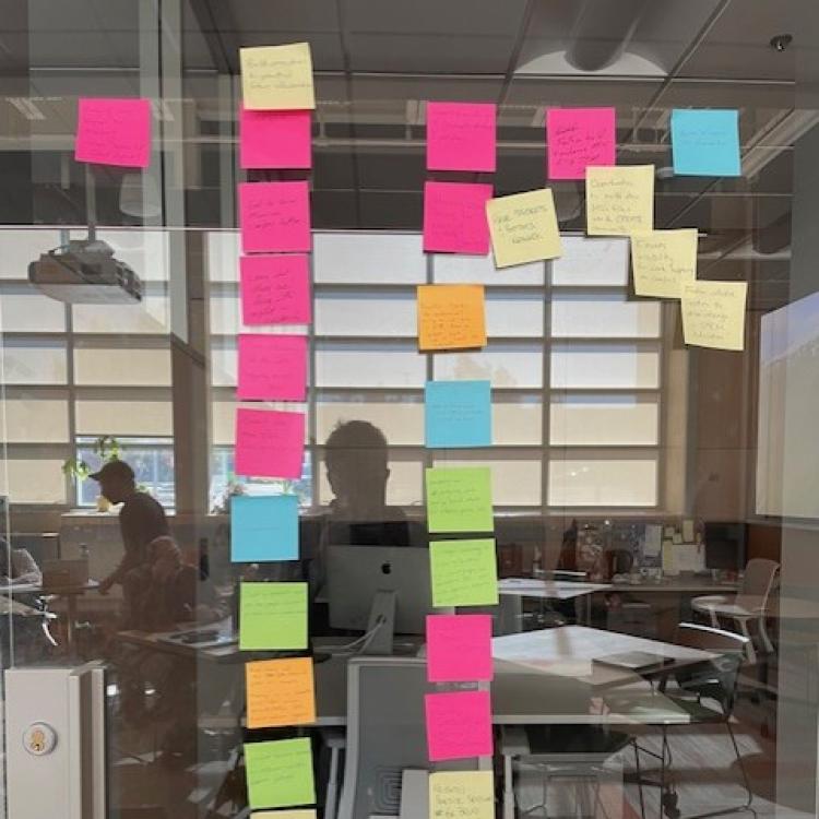 Post-it notes with suggestions on glass wall