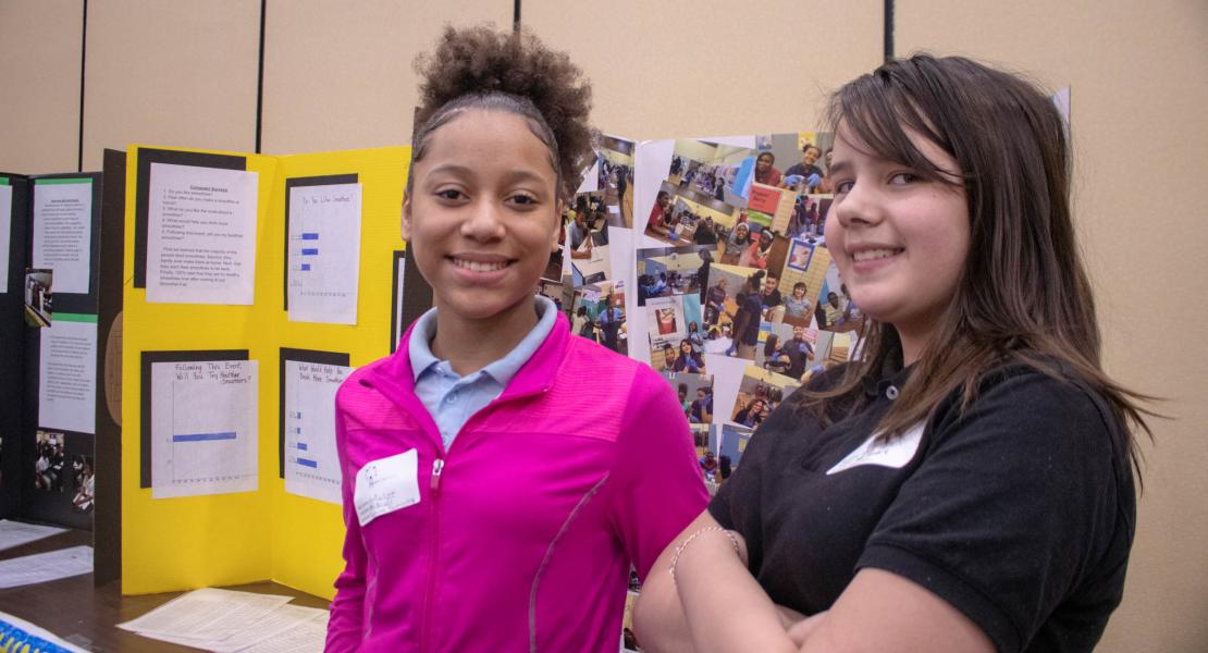 Girls in front of poster at HiOH Summit