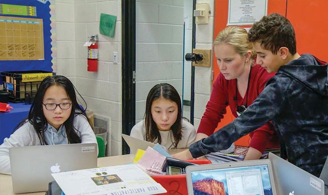 Photo of teachers working with students