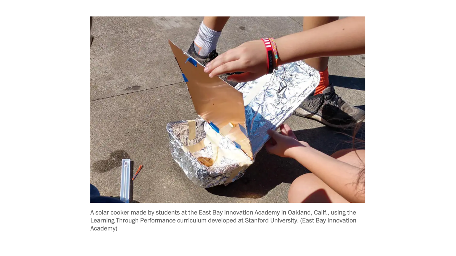 Photo of students outdoors doing a project using aluminum foil and sunlight